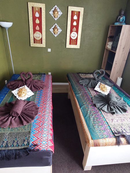 Noi & Tim Traditionelle Thai Massage – Ein liebevoll gestalteter Massageraum mit zwei bequemen Liegen, warmen Farben und traditionellen Stoffen – ideal für Paarmassagen oder gemeinsame Entspannung.